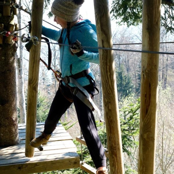 a person sitting on a wooden pole