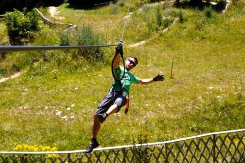 a person that is standing in the grass near a fence